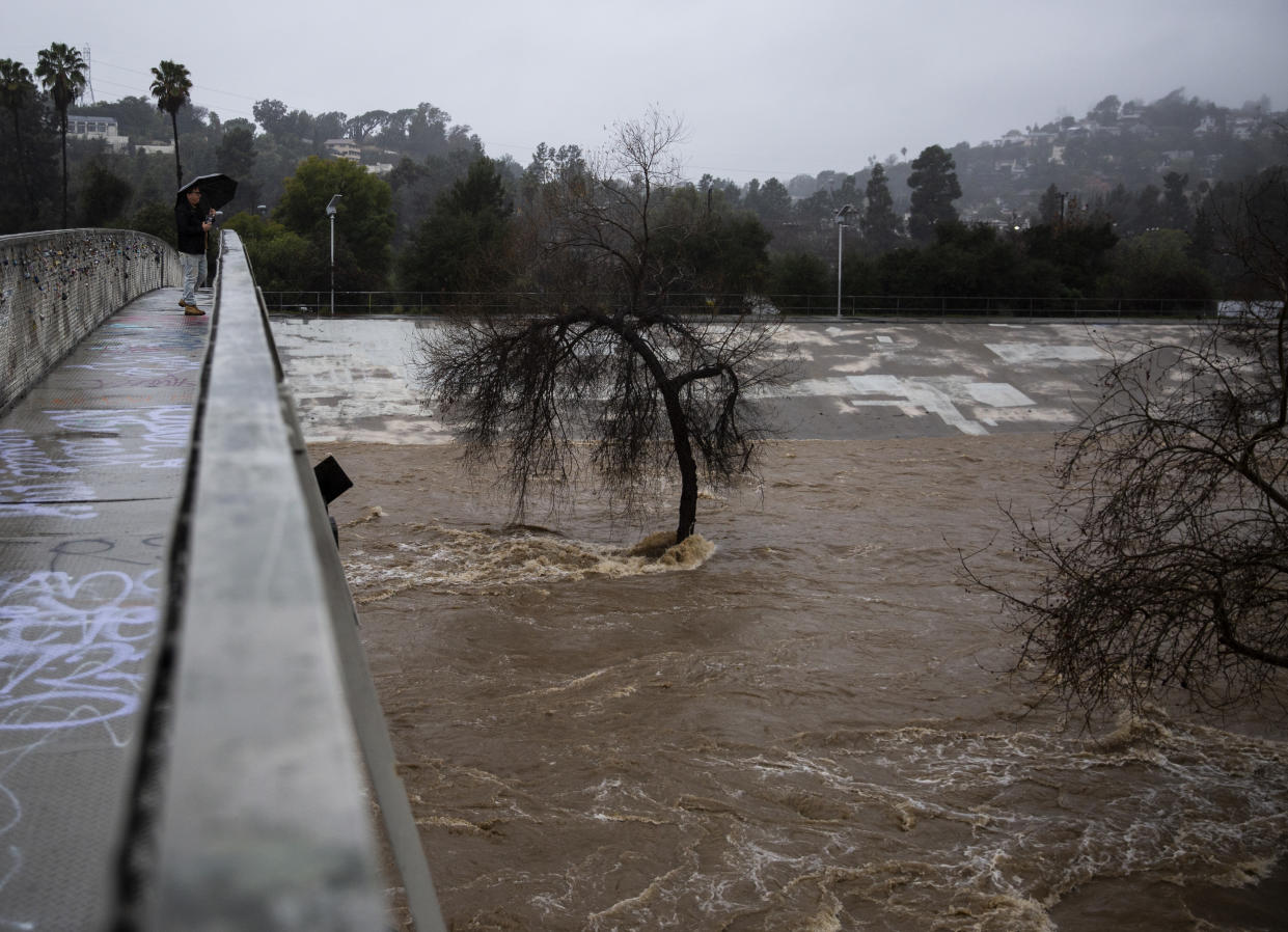 Un peatón observa cómo las riadas descienden por el río Los Ángeles, en Los Ángeles, el lunes 5 de febrero de 2024. (Jenna Schoenefeld/The New York Times)