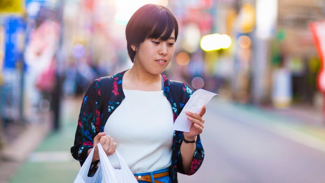 woman checking shopping receipt