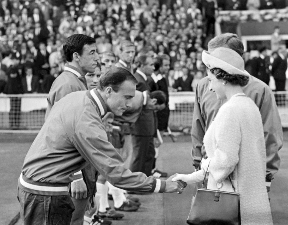 FILE - Britain's Queen Elizabeth II shakes hands with England defender George Cohen as she was introduced the England team before the start of the Football World Cup match between England and Uruguay ay Wembley Stadium, London, on July 11, 1966. George Cohen, the right-back for England World Cup-winning team of 1966, has died aged 83, his former club Fulham have announced on Friday, Dec. 23, 2022. (AP Photo/Bippa, File)