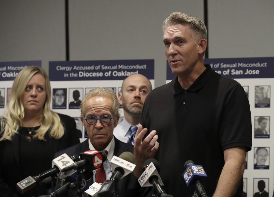 Tom Emens, right, speaks at a news conference in San Francisco, Tuesday, Oct. 23, 2018. A law firm suing California bishops for the records of priests accused of sexual abuse has compiled a report of clergy in the San Francisco Bay Area it says are accused of misconduct. (AP Photo/Jeff Chiu)