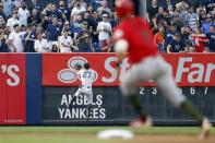 May 26, 2018; Bronx, NY, USA; New York Yankees designated hitter Giancarlo Stanton (27) collides with the wall chasing an RBI double by Los Angeles Angels center fielder Mike Trout as Los Angeles Angels third baseman Zack Cozart (7) rounds second base during the first inning at Yankee Stadium. Mandatory Credit: Adam Hunger-USA TODAY Sports