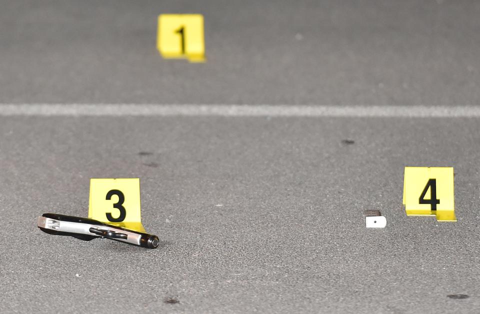 Evidence markers sit next to a handgun and magazine.