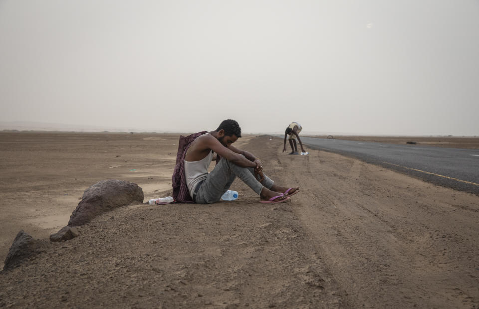 In this July 21, 2019 photo, Ethiopian migrants rest on the side of a highway in Lahj, Yemen, early in the morning, as they make their way to Aden. (AP Photo/Nariman El-Mofty)