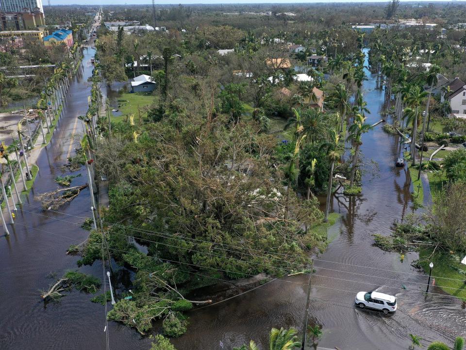 Vehicles make their way through a flooded area after Hurricane Ian passed through on September 29, 2022 in Fort Myers, Fl.