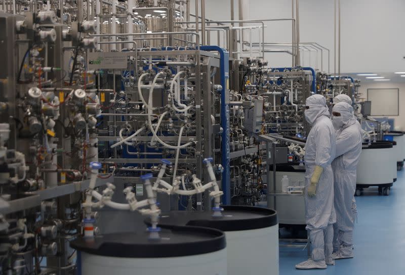 Employees in PPE work inside a lab where the HPV vaccine is produced at the Serum Institute of India, in Pune