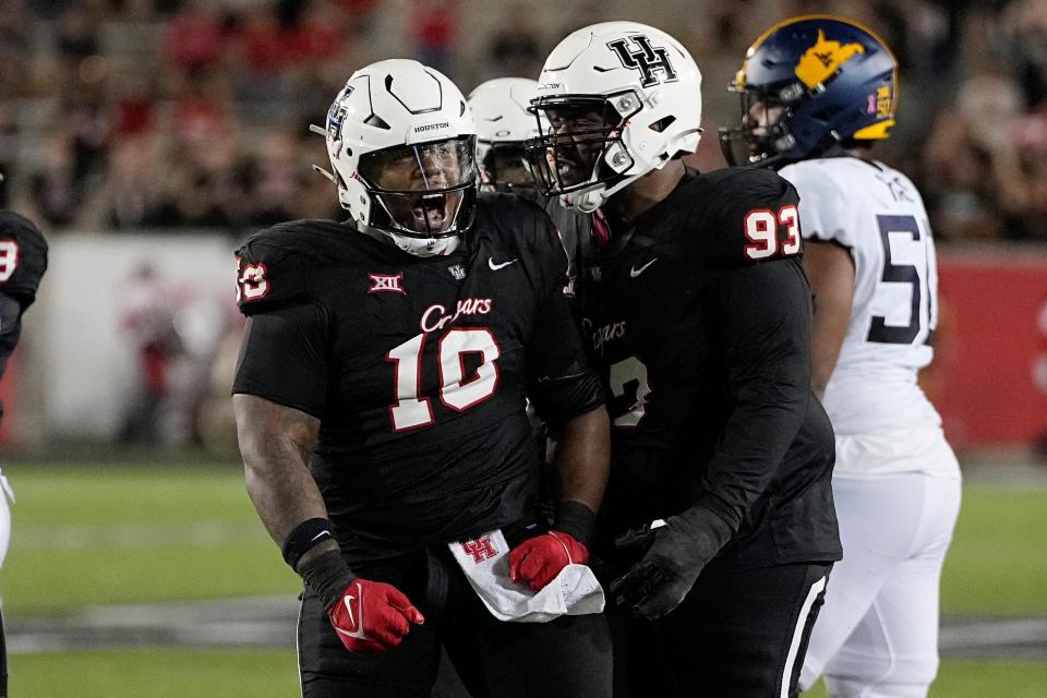 Houston defensive lineman Chidozie Nwankwo (10) celebrates with Jamaree Caldwell (93) after a stop during the second quarter of an NCAA college football game against West Virginia, Thursday, Oct. 12, 2023, in Houston. (AP Photo/Kevin M. Cox)