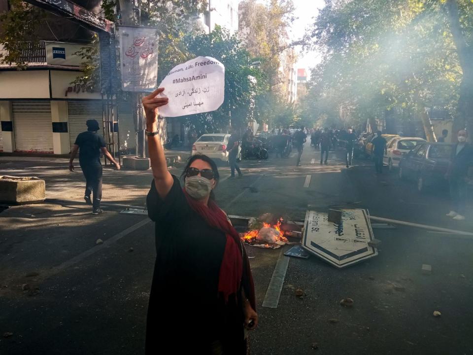 PHOTO: An Iranian woman holds up a paper reading 'Woman, Life, Freedom' and 'Mahsa Amini' during nationwide protests in Tehran, Oct. 1, 2022.  (AFP via Getty)