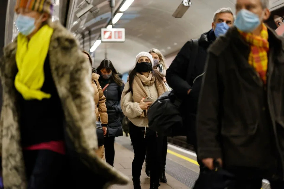 Usuarios del transporte p&#xfa;blico que llevan cubrebocas salen de una estaci&#xf3;n del metro en Londres el 21 de enero de 2022 (AFP via Getty Images)