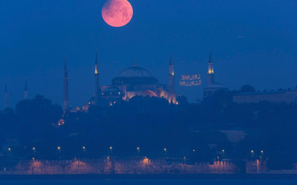 A full moon rises above the iconic Haghia Sophia in Istanbul, Turkey, early Monday - Mucahid Yapici/AP