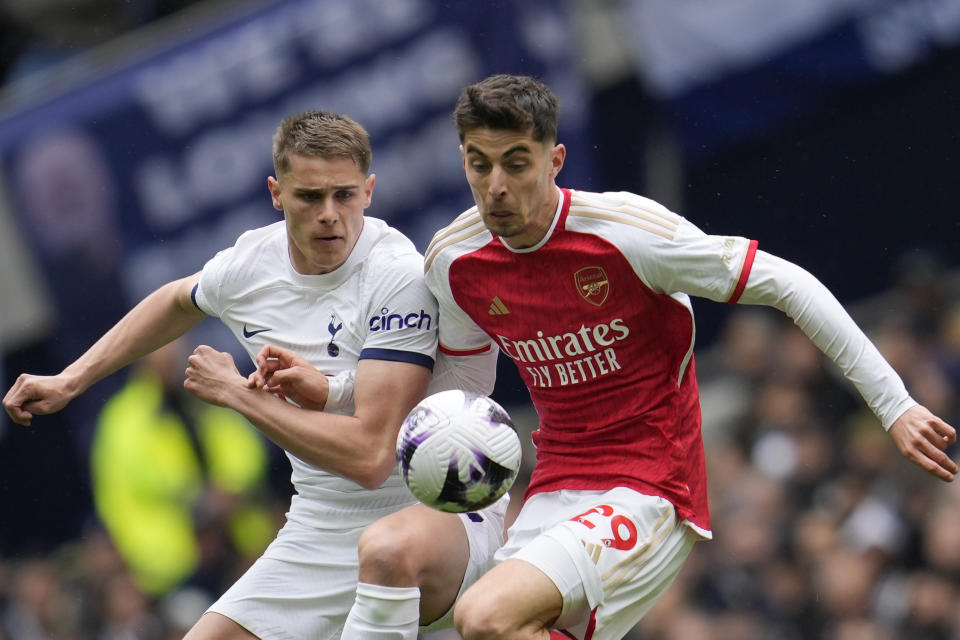 Arsenal's Kai Havertz, right, challenges for the ball with Tottenham's Rodrigo Bentancur during the English Premier League soccer match between Tottenham Hotspur and Arsenal at the Tottenham Hotspur Stadium in London, England, Sunday, April 28, 2024. (AP Photo/Kin Cheung)
