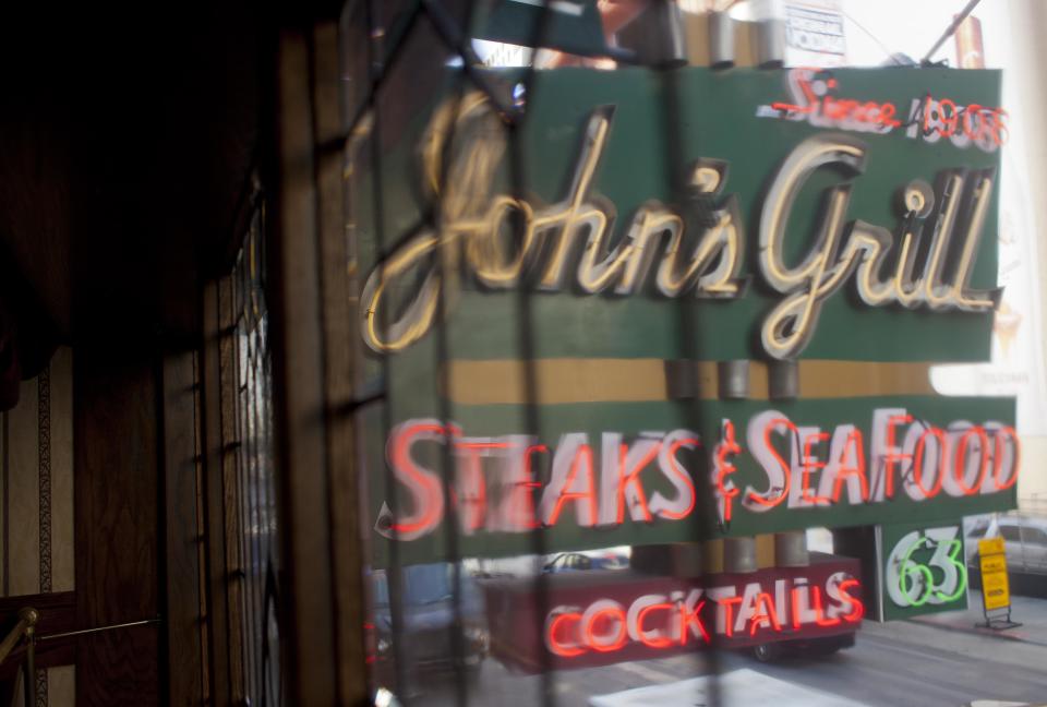 In this photo taken Thursday, Sept. 27, 2012, is the old neon sign hanging above John's Grill in San Francisco. San Francisco has a long history as a favorite site for filmmakers and the movie buffs who want to see the spots where their favorite scenes took place, from Fort Point under the Golden Gate Bridge where Jimmy Stewart saved Kim Novak in "Vertigo" to the steps of City Hall, where Sean Penn gave an impassioned speech in "Milk," to Alcatraz, stage for Clint Eastwood and many others. One of the city's oldest restaurants, the grill was a setting in author Dashiell Hammett's “The Maltese Falcon.” The interior looks just as you would picture it from the book, filled with original period furnishings. The walls are covered with photos of famous customers and the second floor has a replica of the falcon, along with movie stills and foreign translations of the novel. (AP Photo/Eric Risberg)