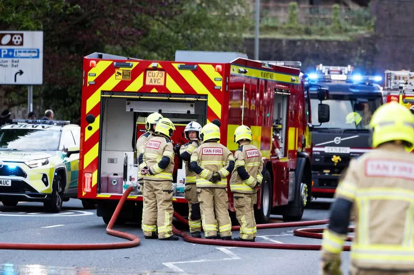 Firefighters with fire engine and hoses