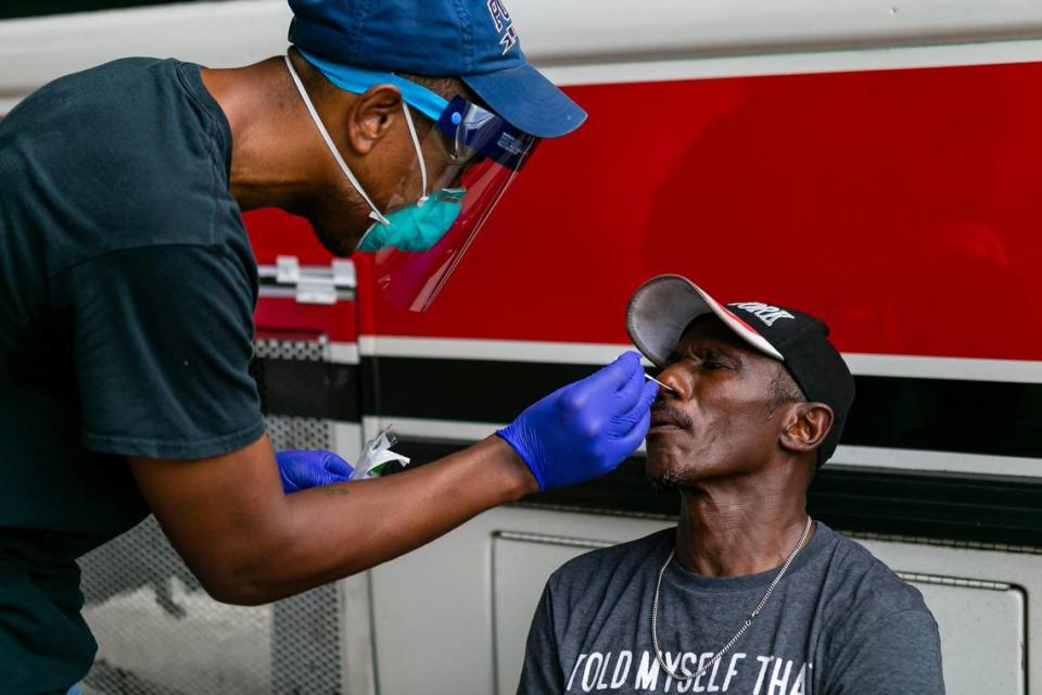 Armen Henderson, a University of Miami internist, conducts a COVID-19 test on Barry Alston in Miami’s Overtown neighborhood on Friday, March 27, 2020.