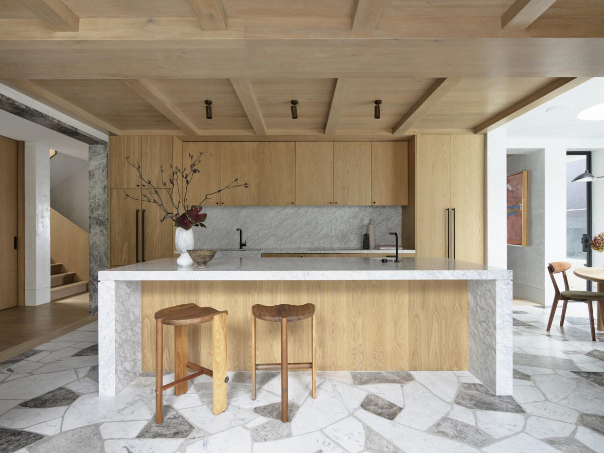  A kitchen with tile flooring and wooden island and cabinets. 
