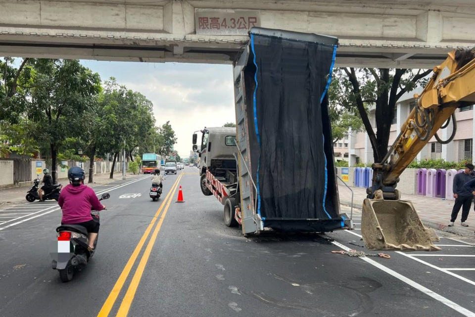 台南1輛大貨車30日上午因車斗未收閉就上路行駛，在新豐高中前路段撞擊人行天橋，導致駕駛受輕傷。（中央社／讀者提供）
