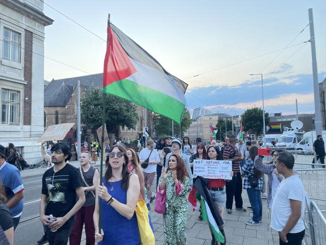 Protesters march with signs and Palestinian flags