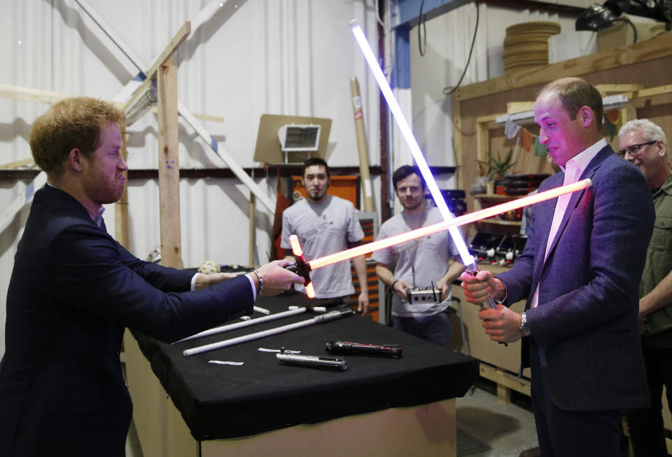 Prince Harry (L) and Prince William, Duke of Cambridge try out lightsabers during a tour of the Star Wars sets at Pinewood studios on April 19, 2016 in Iver Heath, England. Prince William and Prince Harry are touring Pinewood studios to visit the production workshops and meet the creative teams working behind the scenes on the Star Wars films.