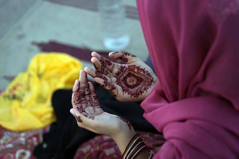 A woman has her hands painted with traditional henna as she attends Eid al-Adha prayers at historical Badshahi mosque in Lahore, Pakistan, Monday, June 17, 2024. Eid al-Adha or Feast of Sacrifice, the most important Islamic holiday, marks the willingness of the Prophet Ibrahim, Abraham to Christians and Jews, to sacrifice his son. During the holiday, which in most places lasts three days, Muslims slaughter goat, sheep or cattle, distribute part of the meat to the poor. (AP Photo/K.M. Chaudary)