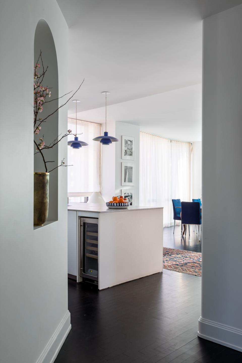 McGrath chopped two feet off the kitchen island to make the entryway feel more open, and brightened things with two of four cobalt blue PH 4/3 Louis Poulsen sconces (their mates frame the master bed).