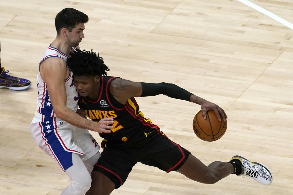 Atlanta Hawks forward De'Andre Hunter (12) drives against Philadelphia 76ers guard Dakota Mathias (33) during the first half of an NBA basketball game Monday, Jan. 11, 2021, in Atlanta. (AP Photo/John Bazemore)