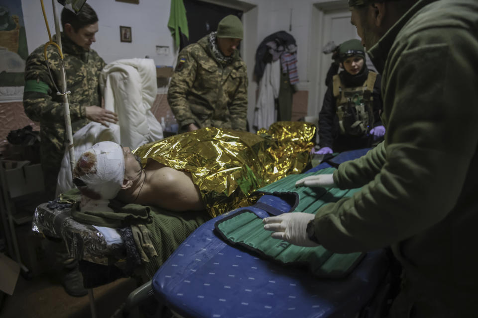 Medics give the first aid to a wounded Ukrainian soldier near Bakhmut, the site of the heaviest battles with the Russian troops, Donetsk region, Ukraine, Monday, Feb. 27, 2023. (AP Photo/Yevhen Titov)