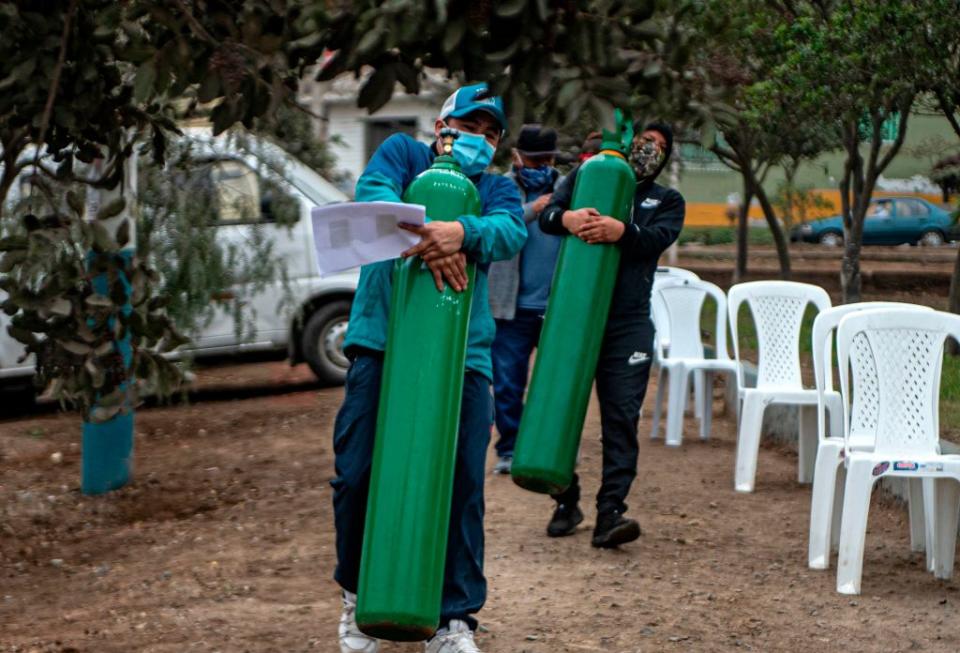 Relatives of COVID-19 patients move oxygen cylinders as they queue to recharge them in Villa Maria del Triunfo, in the southern outskirts of Lima last week.