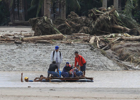 Residents are transported on a makeshift raft after a bridge was destroyed during flash floods in Salvador, Lanao del Norte in southern Philippines, December 23, 2017. REUTERS/Richel V. Umel