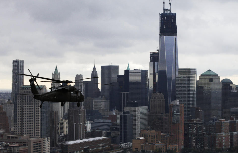 A New York Air National Guard helicopter flies past lower Manhattan, Wednesday, Oct. 31, 2012 in New York. Gov. Andrew Cuomo, Sen. Kirsten Gillibrand, D-NY, Sen. Charles Schumer, D-NY, and local officials took the flight over the city, Nassau and Westchester counties to get an assessment of damages from superstorm Sandy. (AP Photo/Mark Lennihan)