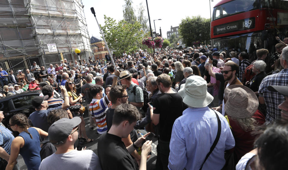 The road is blocked and the crossing obscured as thousands of fans gather to walk across the Abbey Road zebra crossing on the 50th anniversary of British pop musicians The Beatles doing it for their album cover of 'Abbey Road' in St Johns Wood in London, Thursday, Aug. 8, 2019. They aimed to cross 50 years to the minute since the 'Fab Four' were photographed for the album. (AP Photo/Kirsty Wigglesworth)