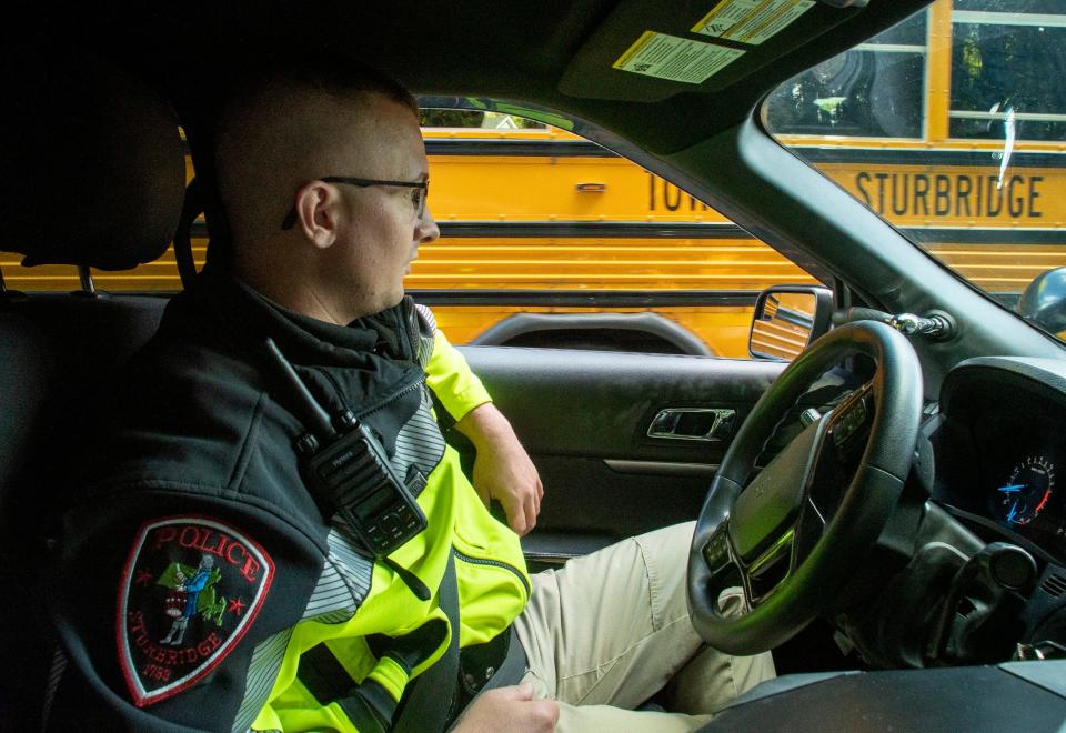 Sturbridge Police Officer Nicholas Mardirosian allows a school bus carrying Tantasqua Regional High School students to pass so he can follow behind and observe stops on Main Street Thursday.