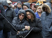 Kerry Smooke, center left, and daughter Molly Feinberg, right center, attend a Shabbat morning service by Rabbi Chuck Diamond outside the Tree of Life Synagogue Saturday, Nov. 3, 2018 in Pittsburgh. About 100 people gathered in a cold drizzle for what was called a "healing service" outside the synagogue that was the scene of a mass shooting a week ago. (AP Photo/Gene J. Puskar)