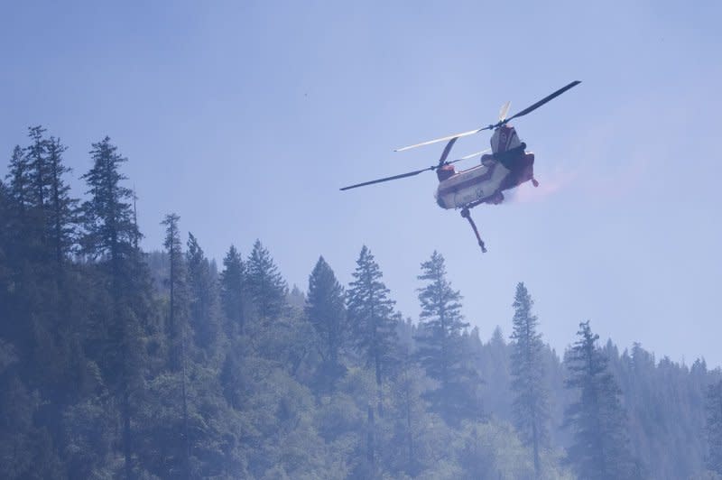 A CalFire helicopter heads to make a retardant drop on the Dixie fire above the Plumas National Forest in Plumas and Butte Counties in July 2021. Wildfires were raging in many western states. File Photo by Peter DaSilva/UPI