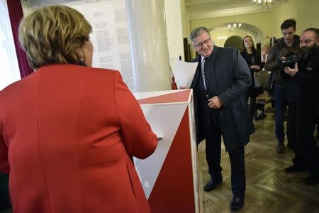 Former Poland's president Bronislaw Komorovski and wife Anna (L) prepare to cast their ballots at a polling station in Warsaw, Poland October 25, 2015. REUTERS/Agencja Gazeta/Franciszek Mazur