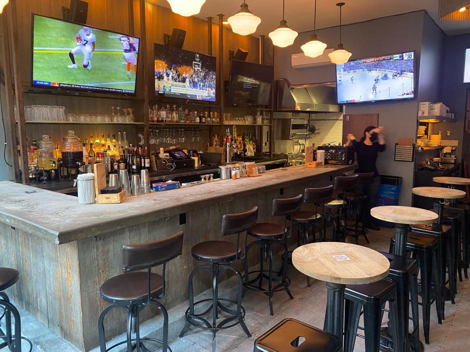 A bar with flat screen televisions mounted on the walls.