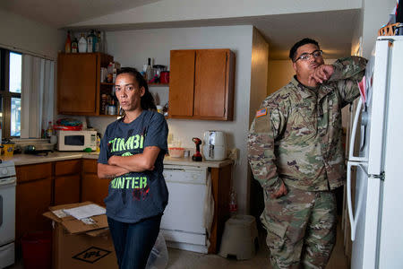 FILE PHOTO: Leanne Bell, 39, and her husband, Spc. Tevin Mosley, 26, who say they began suffering breathing issues, depression, and rashes, they attribute to a mold infestation, since moving into the army base housing allocated to their family in Fort Hood 3 years ago pose in the kitchen of their house in Fort Hood, Texas, U.S. May 16, 2019. Over the course of their stay they contacted housing maintenance repeatedly, submitting between 2 to 3 dozen work orders related to mold, HVAC, and air issue quality concerns. In March, the home was quarantined and the family had to be relocated until repairs could be completed. REUTERS/Amanda Voisard