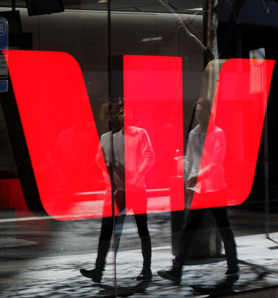 Two men are reflected in a window as they walk past a Westpac bank branch in Sydney, Thursday, Sept. 24, 2020. Westpac, Australia's second-largest bank, agreed to pay a 1.3 billion Australian dollar ($919 million) fine for breaches of anti-money laundering and counterterrorism financing laws, the largest ever civil penalty in Australia, a financial crime regulator said. (AP Photo/Rick Rycroft)