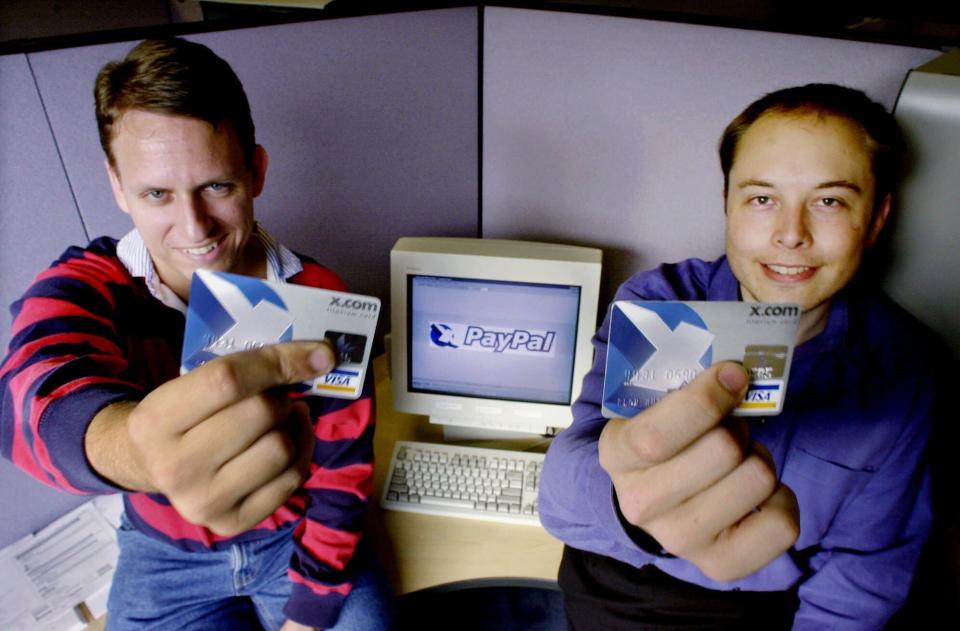 Peter Thiel and Elon Musk holding Visa credit cards