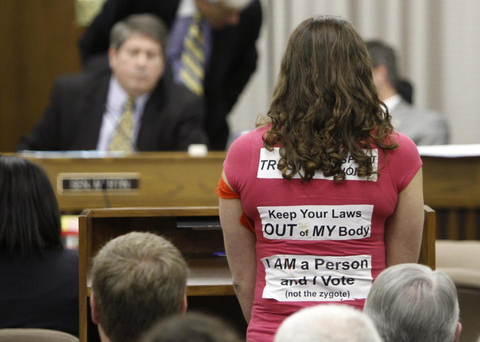 A woman wearing stickers supporting Women's rights speaks during a meeting of the Senate Education and Health committee at the Capitol in Richmond, Va., Thursday, Feb. 23, 2012. (AP Photo/Steve Helber)