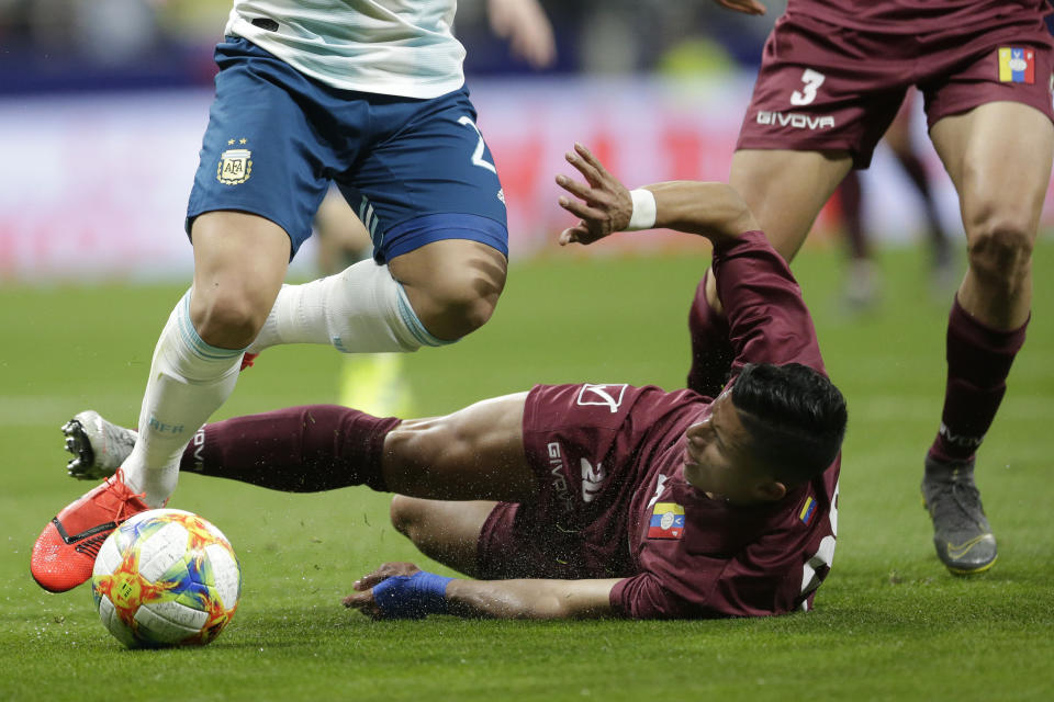 Venezuela's Ronald Hernandez, on the ground, fights for the ball with Argentina's Lautaro Martinez, left, during an international friendly soccer match between Argentina and Venezuela at Wanda Metropolitano stadium in Madrid, Spain, Friday, March 22, 2019. (AP Photo/Bernat Armangue)