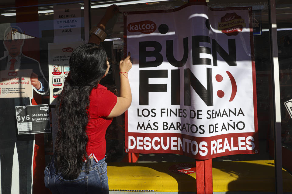 Una empleada de una empresa coloca un cartel que anuncia descuentos como parte de 'El buen fin' el 10 de noviembre de 2020 en Hermosillo, México. (Foto de Luis Gutierrez / Norte Photo / Getty Images)