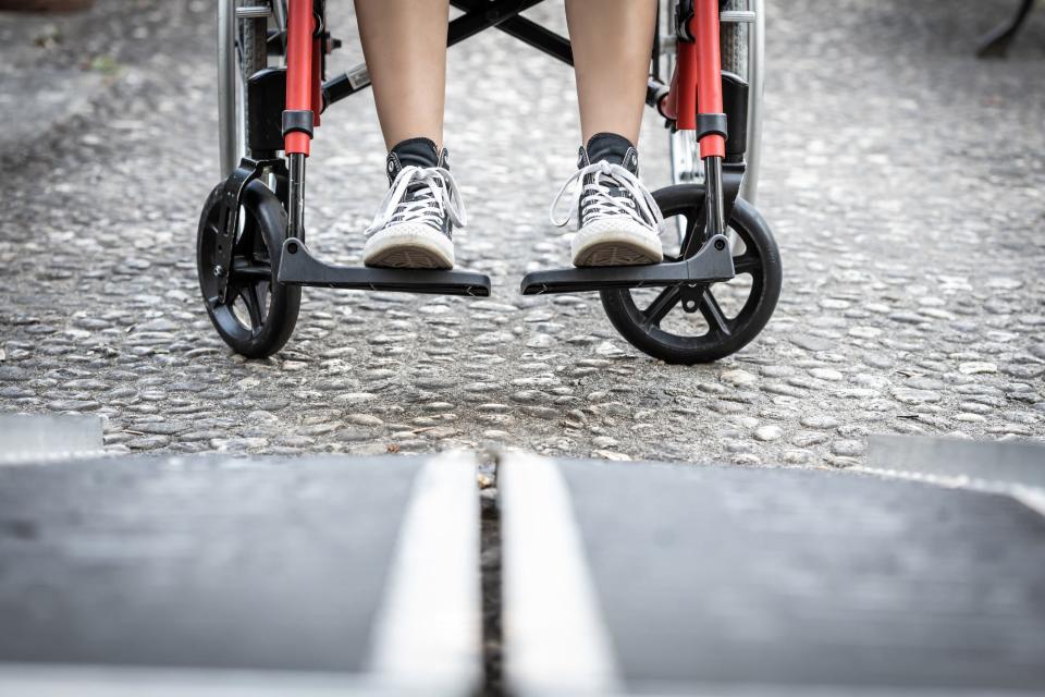 Eine Person, die sich auf das Betreten einer Rollstuhlrampe vorbereitet. (Symbolbild) - Copyright: Manu Vega/Getty Images