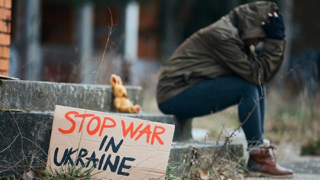 Mujer desesperada con cartel que dice: &quot;Paren la guerra en Ucrania&quot;.