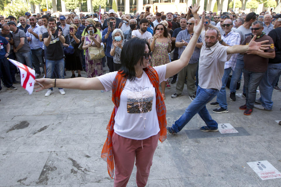 Opponents of the march dance as they block off the capital's main avenue to an LGBT march in Tbilisi, Georgia, Monday, July 5, 2021. A protest against a planned LGBT march in the Georgian capital turned violent on Monday as demonstrators attacked journalists. Organizers of the Tbilisi March For Dignity that was to take place in the evening cancelled the event, saying authorities had not provided adequate security guarantees. (AP Photo/Shakh Aivazov)