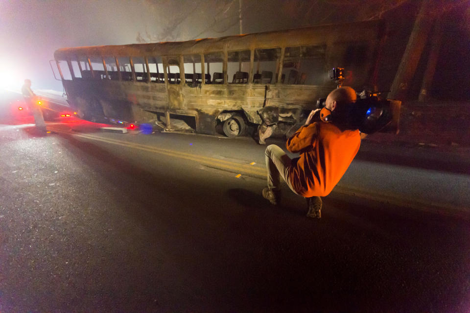 A photographer captures image of a burned out school bus (PA)