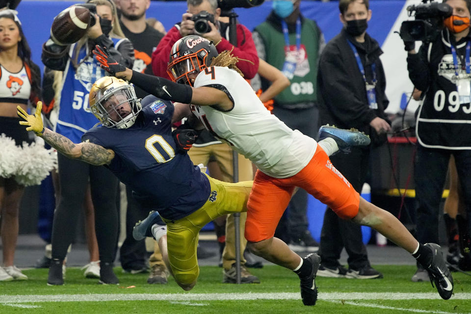 Oklahoma State cornerback Korie Black (4) knocks the ball away from Notre Dame wide receiver Braden Lenzy (0) during the second half of the Fiesta Bowl NCAA college football game, Saturday, Jan. 1, 2022, in Glendale, Ariz. (AP Photo/Rick Scuteri)