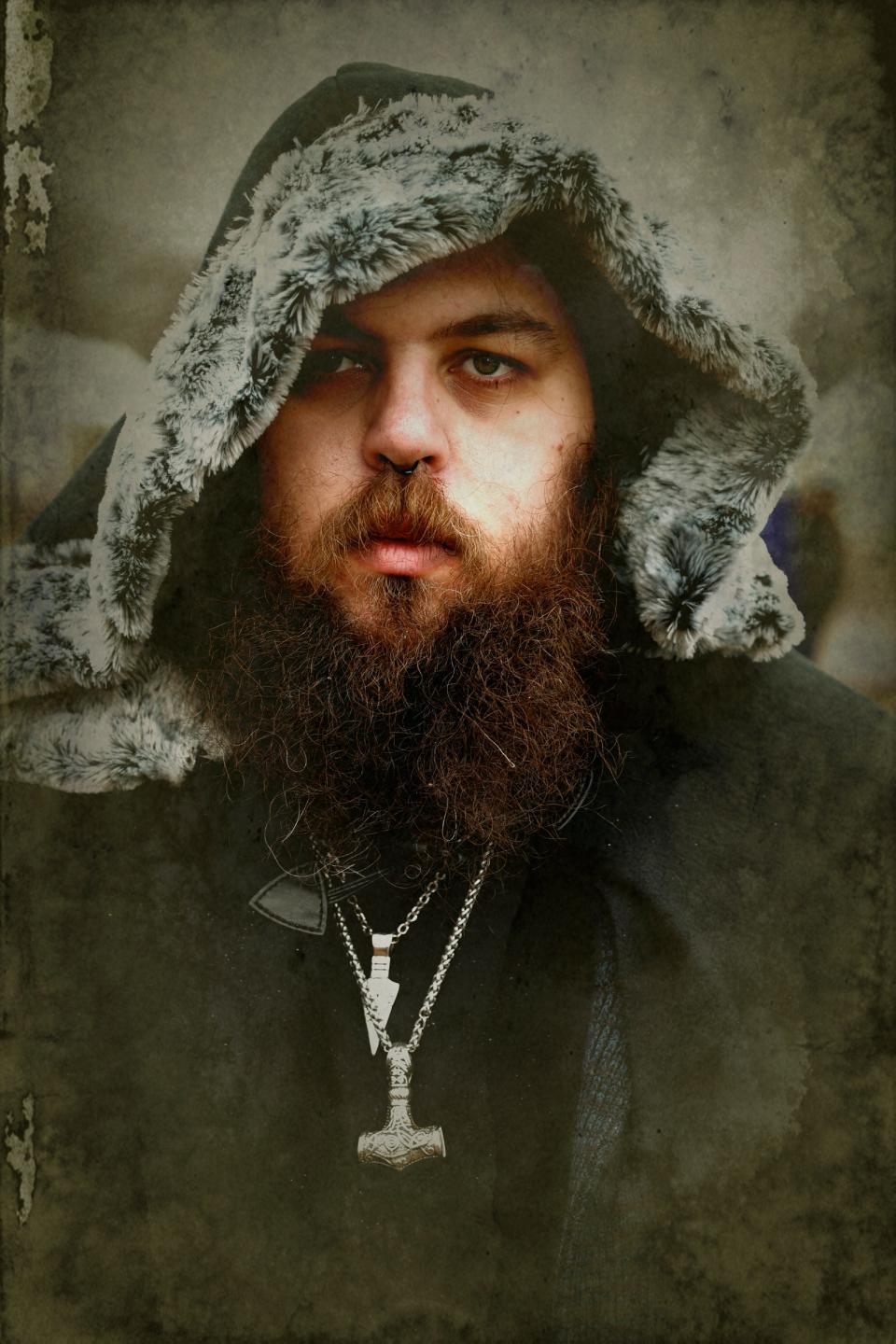 Vincent Barker, 29, of Detroit, with his cloak and Viking jewelry that he wore to the Michigan Nordic Fire Festival at the Eaton County Fairgrounds in Charlotte on Saturday, Feb. 25, 2023.