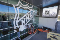 FILE - Workers put up signs celebrating the awarding of a new NHL team to Utah at the Delta Center Thursday, April 18, 2024, in Salt Lake City. It may look like an NHL team has just fallen into Salt Lake City's lap. But local organizers say the Arizona Coyotes' relocation to Utah is the product of a yearslong effort to beckon professional hockey and other elite sports to the capital city. (AP Photo/Rick Bowmer, File)