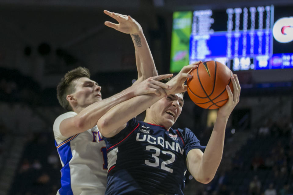 Florida forward Colin Castleton, left, and Connecticut center Donovan Clingan (32) vie for a rebound during the second half of an NCAA college basketball game Wednesday, Dec. 7, 2022, in Gainesville, Fla. (AP Photo/Alan Youngblood)