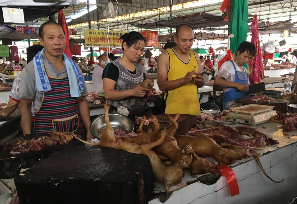 Vendors stand behind a pile of dog meat at the Nanqiao market in Yulin, in China's southern Guangxi region on June 21, 2017. China's most notorious dog meat festival opened in Yulin on June 21 with butchers hacking slabs of canines and cooks frying the flesh following rumours that authorities would impose a ban this year. / AFP PHOTO / BECKY DAVIS        (Photo credit should read BECKY DAVIS/AFP/Getty Images)