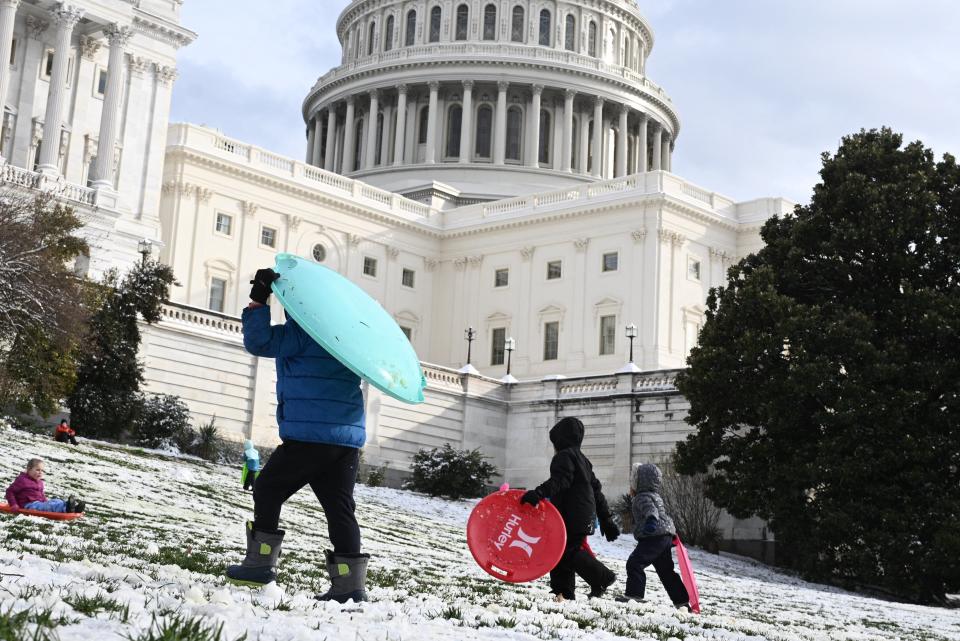 People carry sleds up a hill by the US Capitol in Washington, DC (AFP via Getty Images)